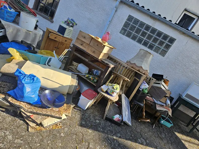 Hof vor der Entrümpelung mit Möbeln, Kisten und Säcken